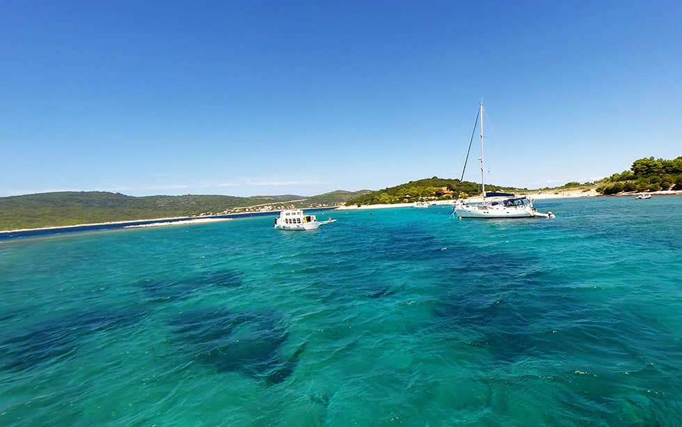 Yacht at sea bay and sandy beach